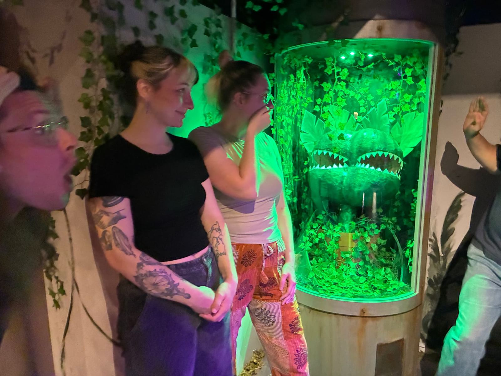 Players reacting to the giant venus flytrap prop inside Little Greenhouse of Horrors at MindEscape Philadelphia